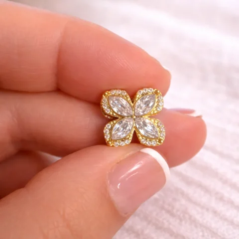 Anillo Daisy dorado con circonitas sujetado entre los dedos