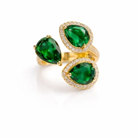 anillo Esmeria dorado con piedras verdes en exposición elegante sobre fondo blanco