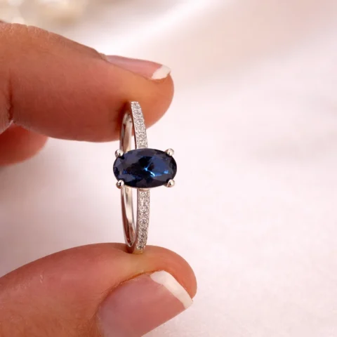 Anillo Luma Blue sujetado entre los dedos detalle