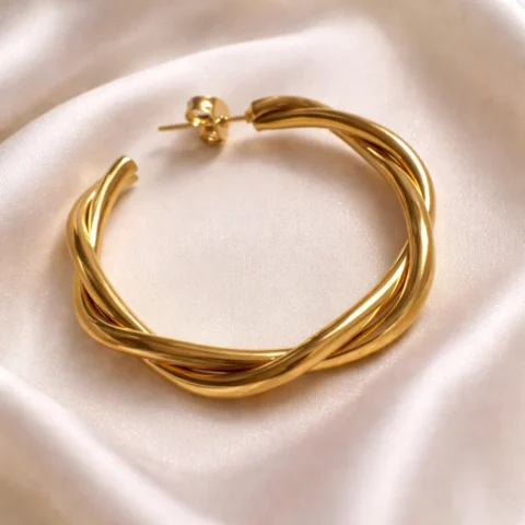 Aros Astra dorados sobre tela de seda elegante