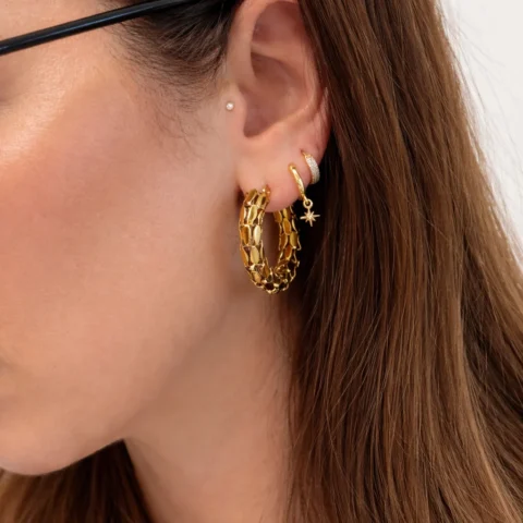 Aros dorados de eslabones puestos en oreja combinados con otros piercings