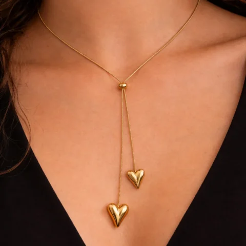 Collar doble corazón dorado ajustable puesto en cuello con vestido negro