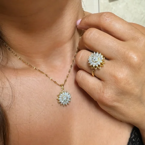 anillo Helios dorado con girasol giratorio de circonitas puesto en mano