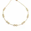 collar Infinia dorado con símbolos infinito sobre fondo blanco
