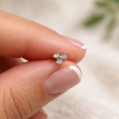 Piercing Nexa Bloom con circonitas sostenido entre los dedos