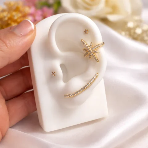 Trepador Nova dorado con circonitas brillantes en expositor de oreja sobre fondo natural elegante