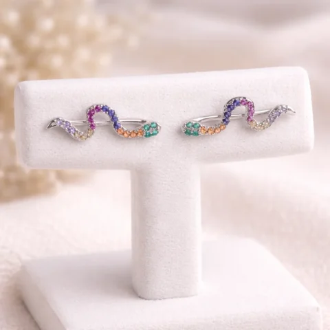 pendientes trepadores serpentina multicolor en expositor elegante de joyería