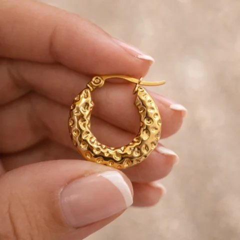 aros terra dorados sostenidos en mano detalle textura orgánica