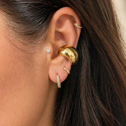Ear cuff dorado Lía Lumière con circonitas puesto en la oreja