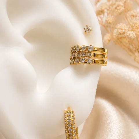Ear cuff dorado Lía Lumière con circonitas puesto en la oreja