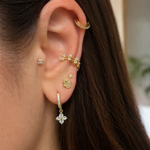 Piercing Nexa Hamsa dorado con circonitas puesto en la oreja