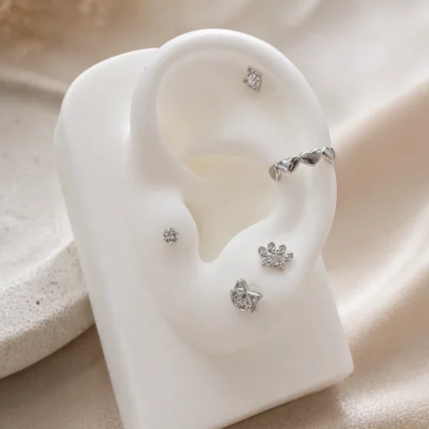 Piercing Nexa Miu plateado en oreja con combinación de pendientes