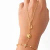 Pulsera de mano Manus Celeste dorada con luna sol y estrella sobre fondo blanco