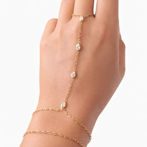 Pulsera de mano Manus Elara dorada con circonitas alineadas sobre fondo blanco