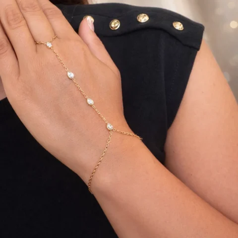 Pulsera de mano Manus Elara dorada con circonitas en mano fondo elegante