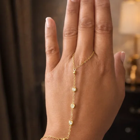 Pulsera de mano Manus Stella dorada con circonitas en mano fondo elegante