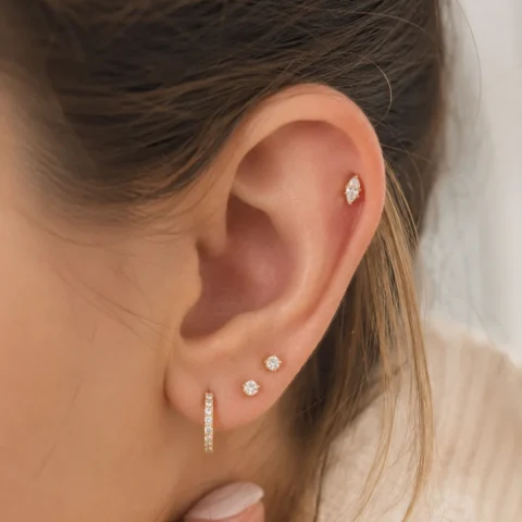 Labret Lumina Marquis dorado colocado en helix con estilo minimalista