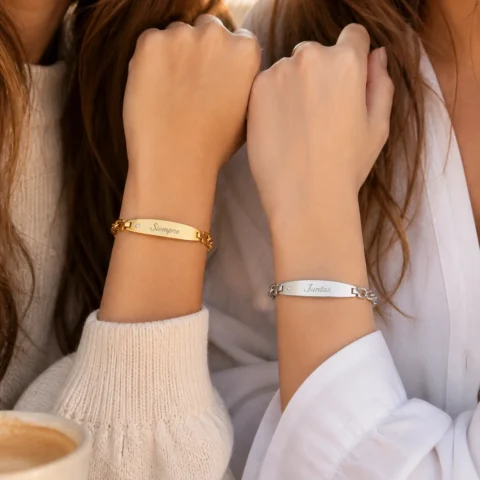 Pulseras personalizadas Élya Luz dorada y plateada en muñecas de amigas con placa grabable