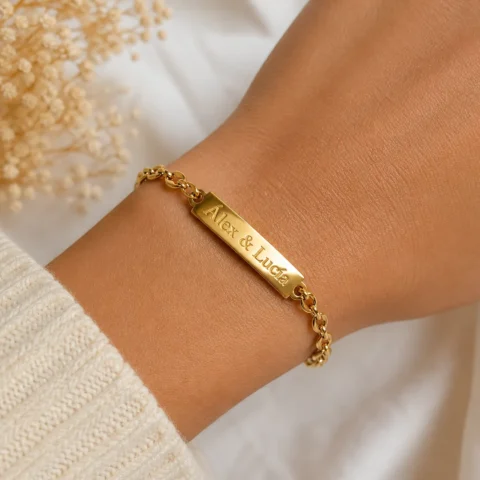 Pulsera dorada personalizada Nexo Unión puesta en muñeca de mujer con grabado brillante